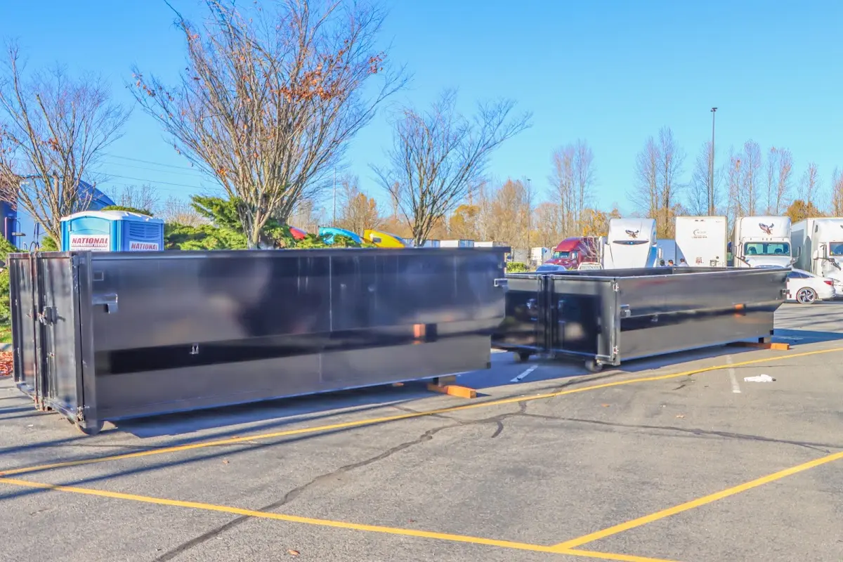 Professional dumpster rental service with roll-off container on residential driveway in West Bridgewater